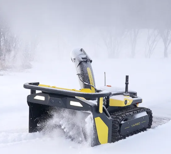 Yellow and black snowblower clearing deep snow in a winter landscape, ready for seasonal storage.
