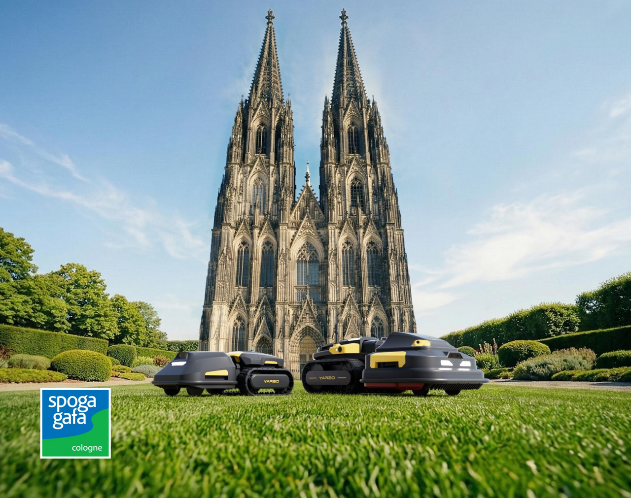 Three black and yellow YARBO robotic mowers on green lawn in front of Cologne Cathedral under blue sky; "spoga gafa cologne" logo bottom left.