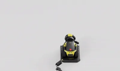 Black and yellow cordless sander on white background, viewed from above, with detached battery below.