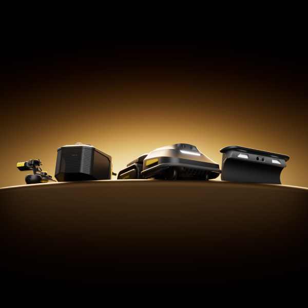 Four black and yellow robotic lawn mowers displayed in a row on a curved surface against a warm gradient background.