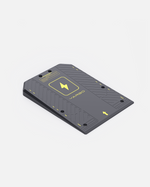 Gray textured docking station with yellow accents and geometric patterns, by Jarbo, shown in angled view with mounting holes and logo.