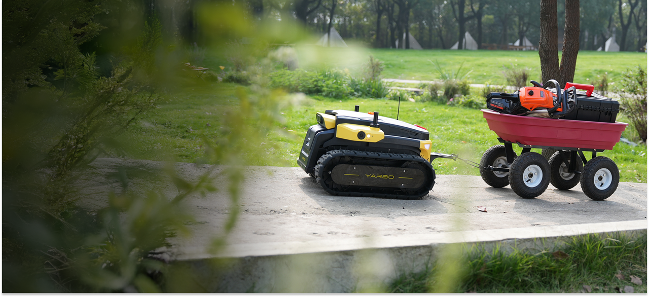 Yellow and black YARBO robotic lawn mower pulls red wagon with tools on concrete path in green garden.