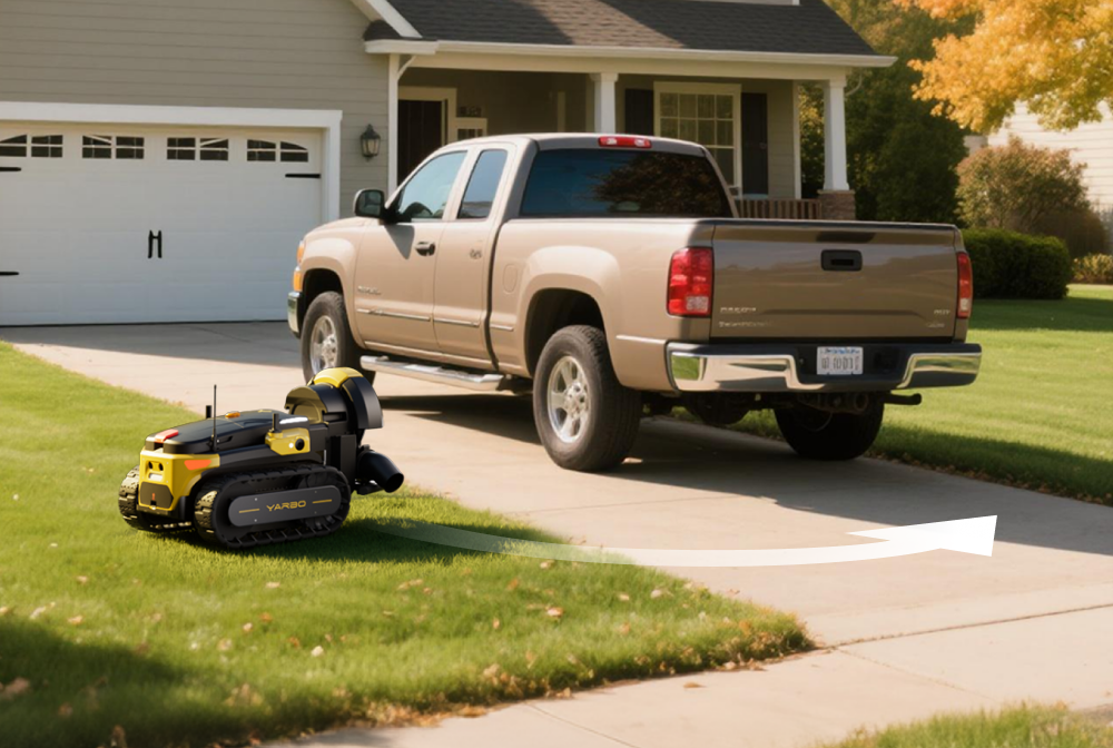 Yellow and black VARBO robotic lawn mower on green grass beside a tan pickup truck in a suburban driveway.